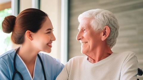 Enfermera en una residencia de personas mayores, conversa con una persona con Alzheimer.