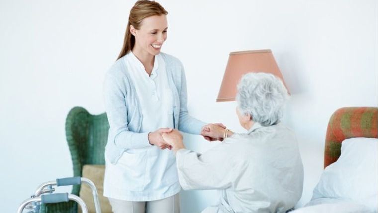 Una anfermera ayuda a una persona mayor.