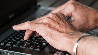 Una persona mayor utiliza un ordenador.