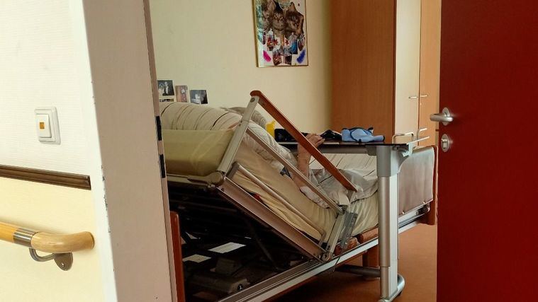 Una persona mayor en la habitación de la residencia.