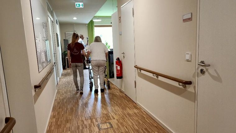 Una persona mayor con su cuidadora en una residencia.
