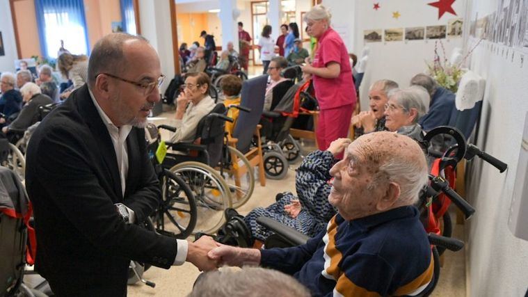 El conseller Carlos Campuzano saluda a un usuario de residencia.