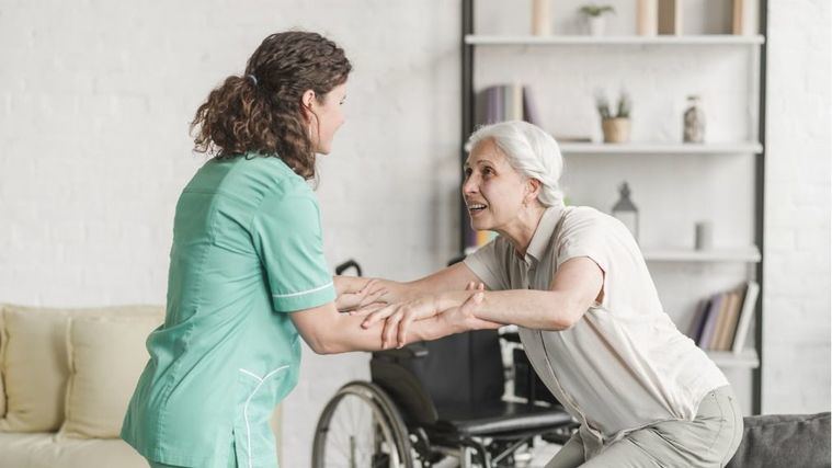 Una enfermera ayuda a una persona mayor.